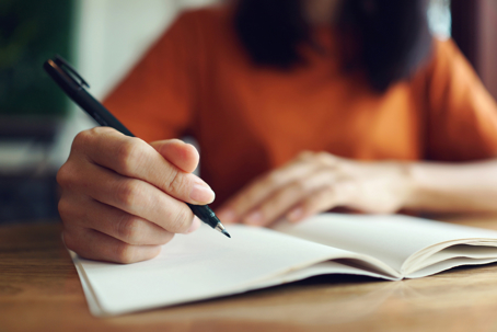 Close up woman hand writing on notebook.