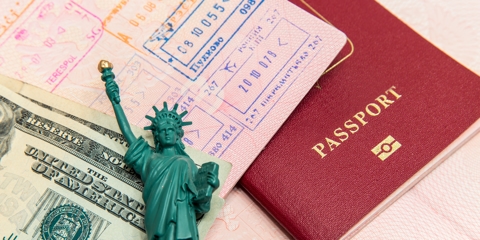 Statue of Liberty figurine next to red passport
