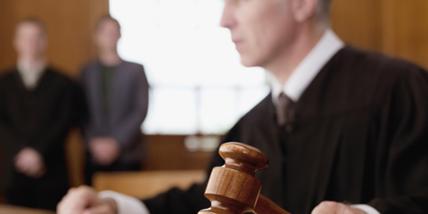 Description Judge holding gavel in courtroom