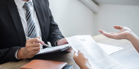 Employer or committee holding reading a resume with talking during about his profile of candidate, employer in suit is conducting a job interview, manager resource employment and recruitment concept.