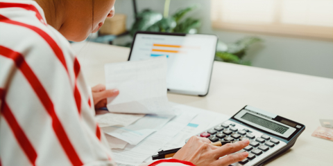 Close-up Young Asian woman with sweater sit front desk with tablet use calculator