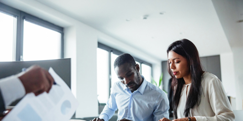 business owner reviewing financial statements or bookkeeping records with an accountant or business advisor in a professional office.