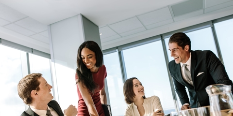 4 attorneys at a conference table smiling