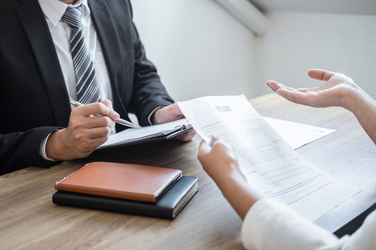 Employer or committee holding reading a resume with talking during about his profile of candidate, employer in suit is conducting a job interview, manager resource employment and recruitment concept.