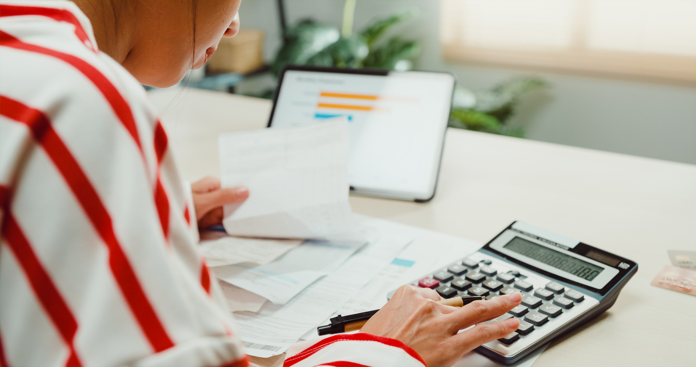 Close-up Young Asian woman with sweater sit front desk with tablet use calculator