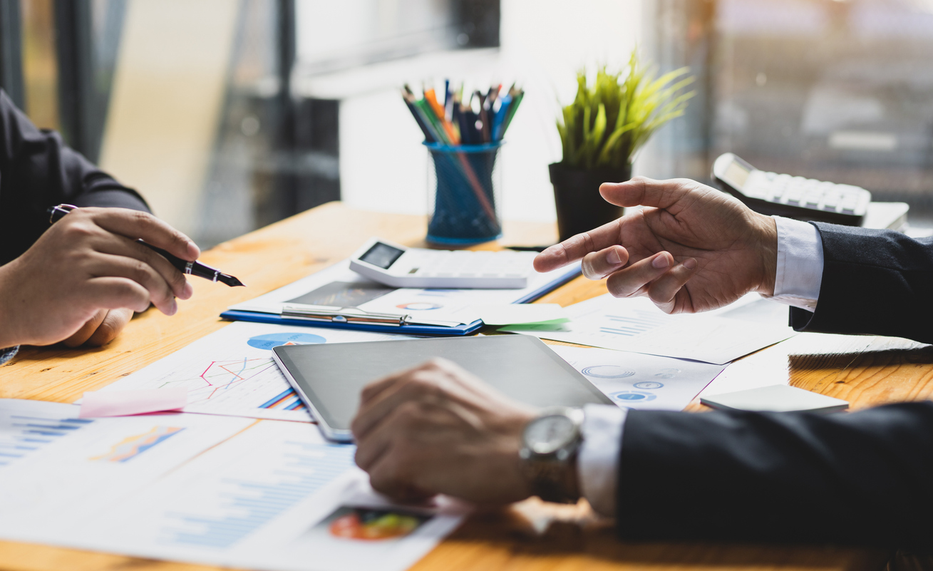 Business people meeting with financial advisors to discuss investment analysis and business strategy planning.