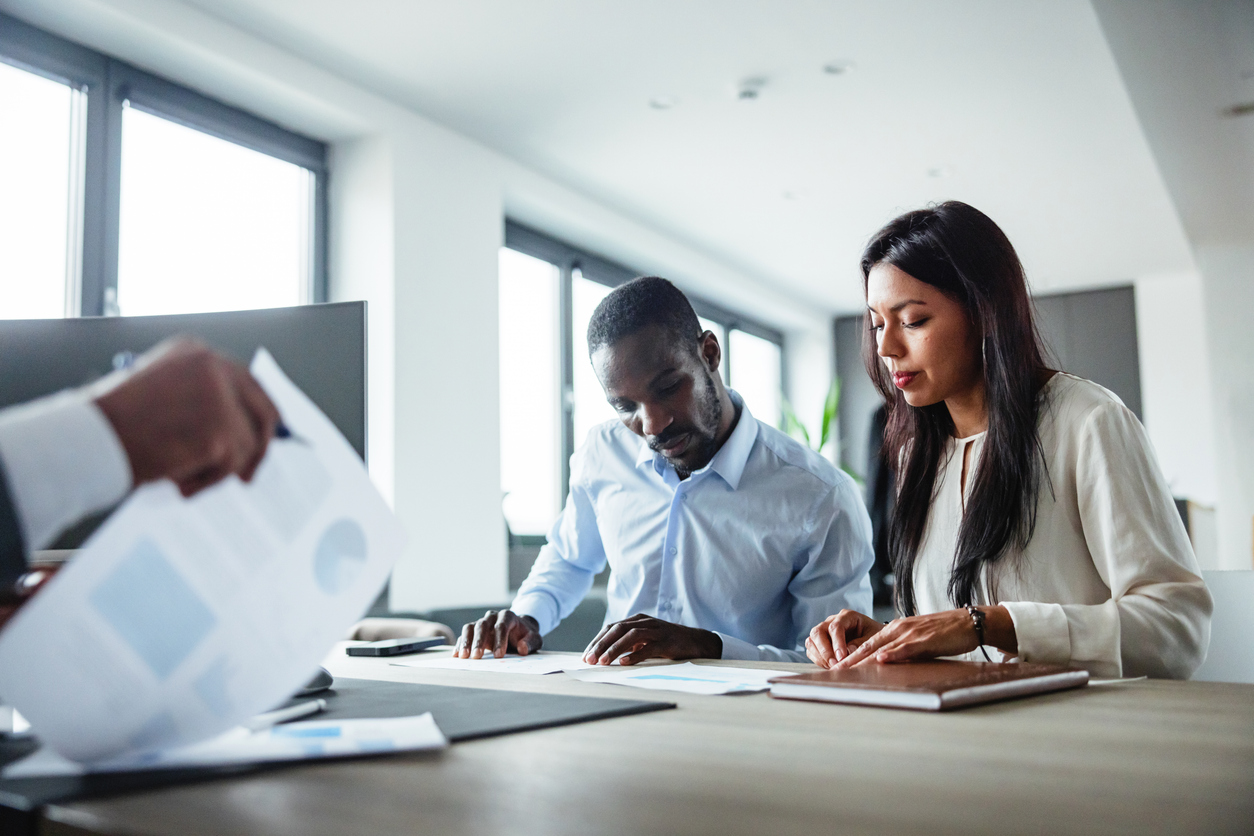 business owner reviewing financial statements or bookkeeping records with an accountant or business advisor in a professional office.