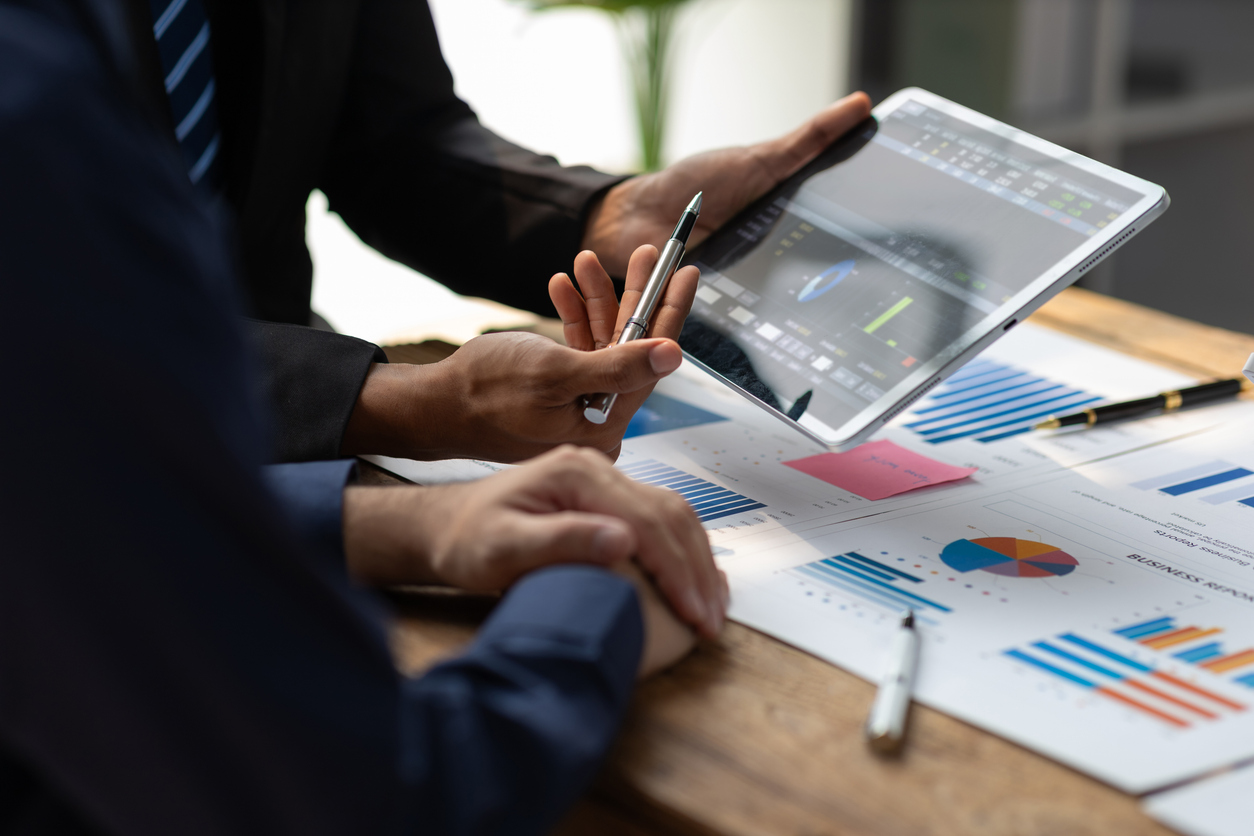 Businessman meeting with consultants discussing data analysis, charts and graphs in financial reports to plan investments and increase company profits.