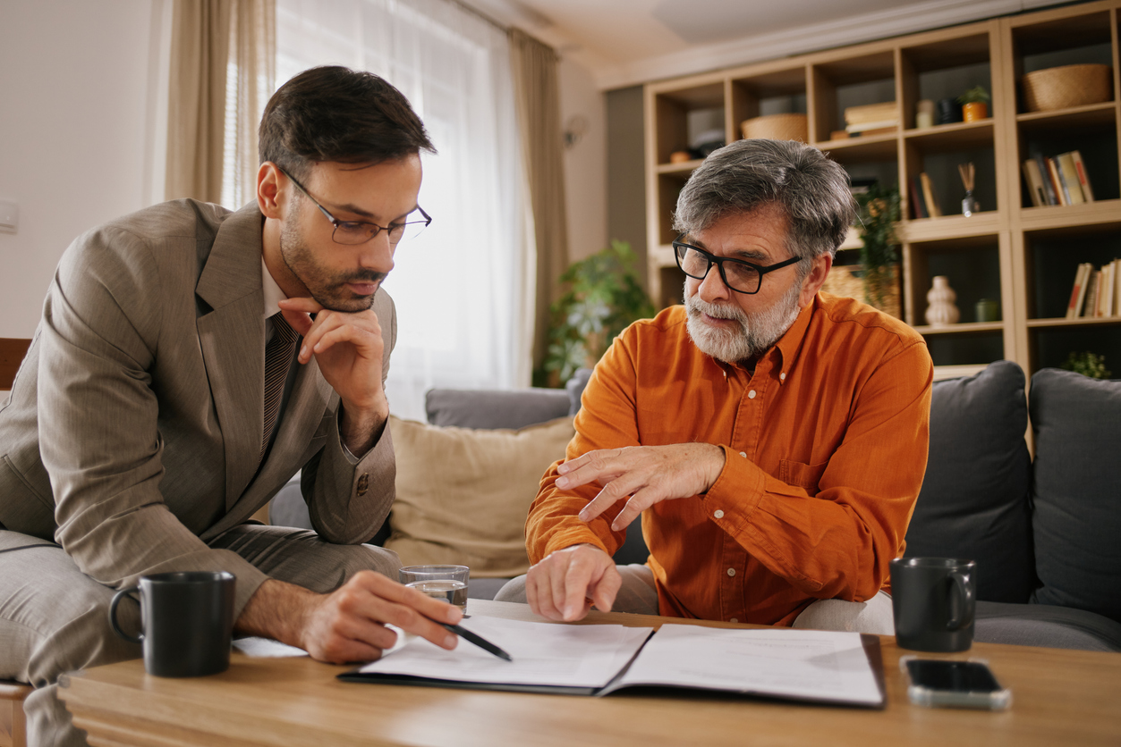 Professional agent discussing financial planning documents with a mature adult client