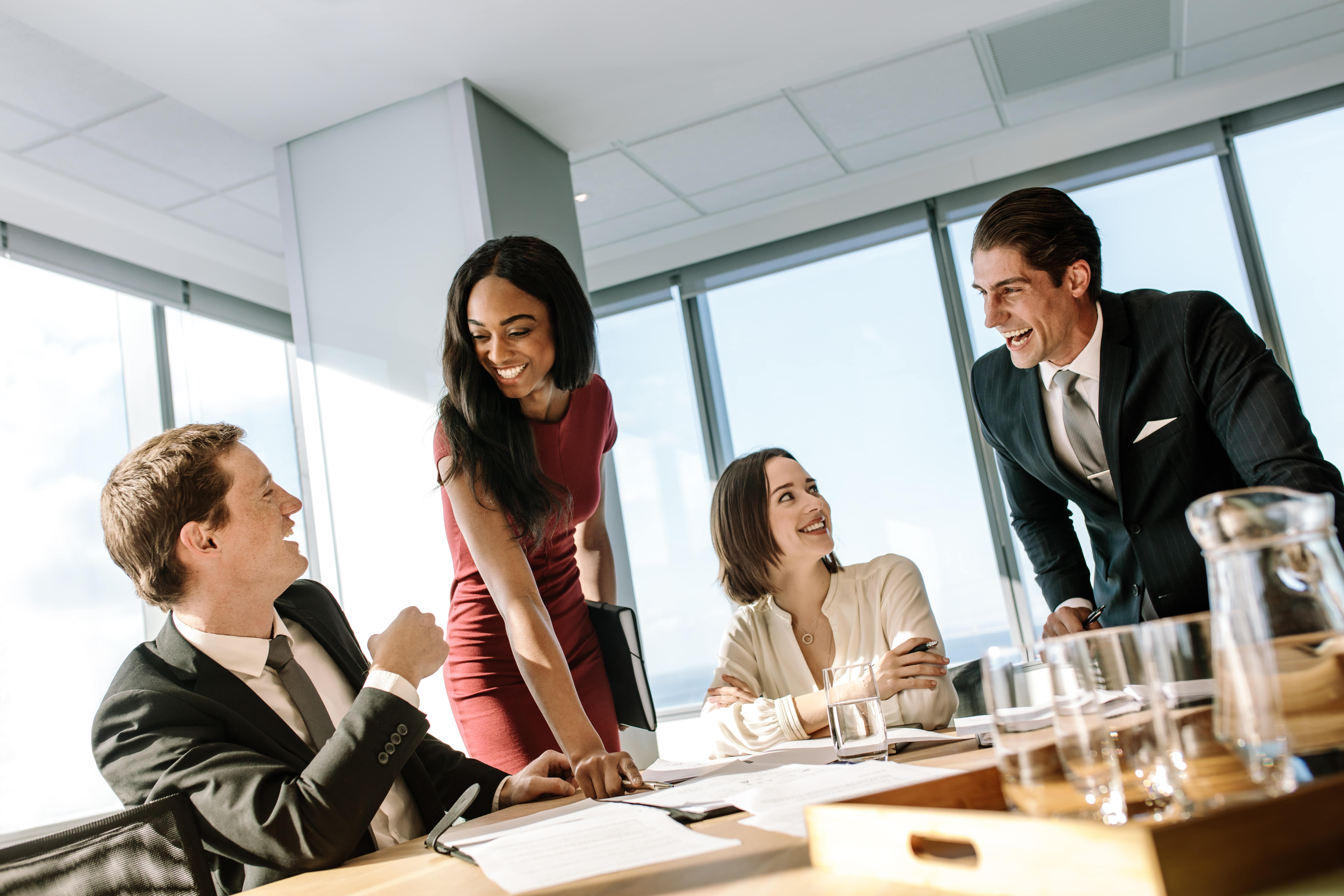4 attorneys at a conference table smiling